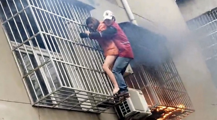 Égő lakásból mentik ki a kínai nőt / Fotó: AFP