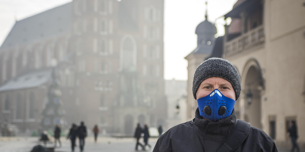 Na zdjęciu: osoba w masce na Rynku Głównym w Krakowie. Miasto zdecydowało się na całkowity zakaz ogrzewania mieszkań węglem