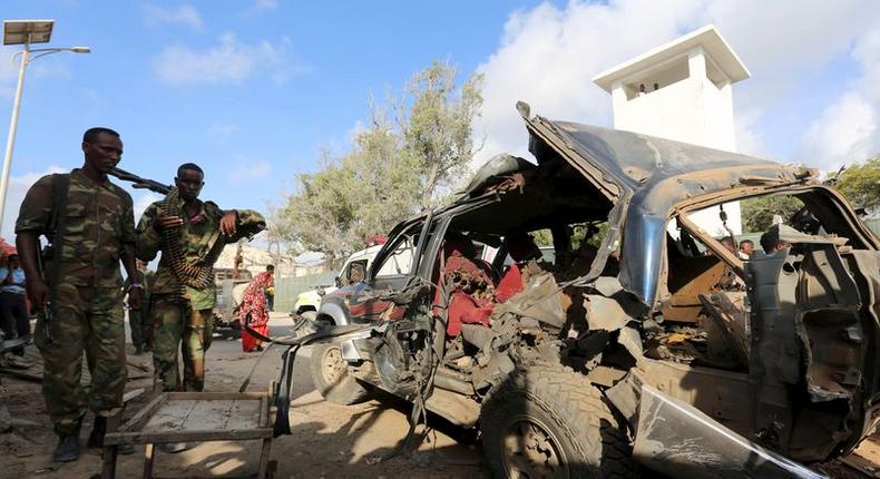 Somali policemen look at the wreckage of a car at the scene of an explosion following an attack in Somalia's capital Mogadishu, March 9, 2016. REUTERS/Feisal Omar