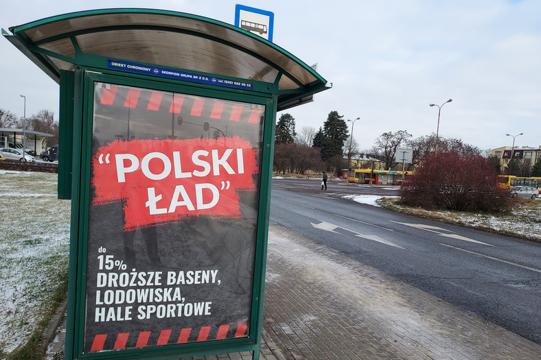 Miejski przystanek w Łodzi z banerem oskarżającym Polski Ład o podwyżki