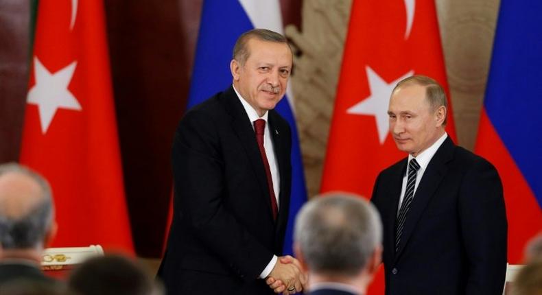 Russian President Vladimir Putin (R) and Turkey's President Recep Tayyip Erdogan shake hands after a joint news conference following their talks at the Kremlin in Moscow on March 10, 2017