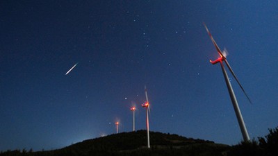 A meteor streaks across the sky during the Perseid meteor shower at a windmill farm near Bogdanci