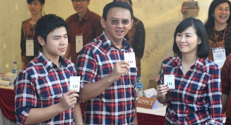 Jakarta's Christian governor Basuki Tjahaja Purnama (C), better known as Ahok, flanked by his wife Veronica (R) and son Nicholas (L) show off their ballot papers in Jakarta on February 15, 2017