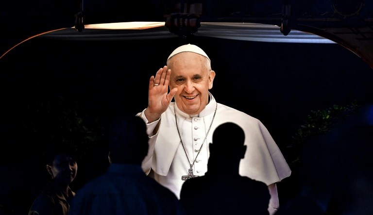 Worshippers gather under a cutout image of Pope Francis at St Mary's Catholic Church in Dubai on January 30, 2019, ahead of the pontiff's visit to the United Arab Emirates