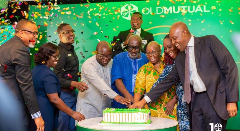 Some management executives, board members and dignitaries cutting the 10th anniversary launch cake of Old Mutual Ghana