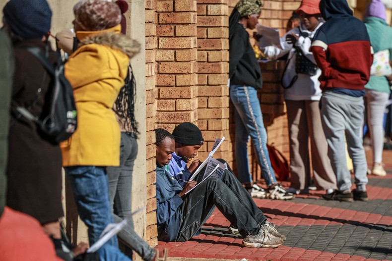 Unemployed people fill in the Department of Unemployment and Labour work seeking registration forms while queuing with others at a centre in Chiawelo, Soweto on June 27, 2025, as they look to be added into the departmentÕs data base. [Photo by PHILL MAGAKOE/AFP via Getty Images]