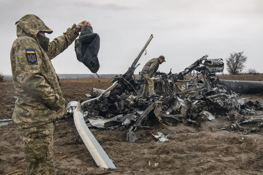Ukraińscy żołnierze dokonują oględzin wraku rosyjskiego śmigłowca Mi-8 w pobliżu Makarowa w kwietniu 2022 r.