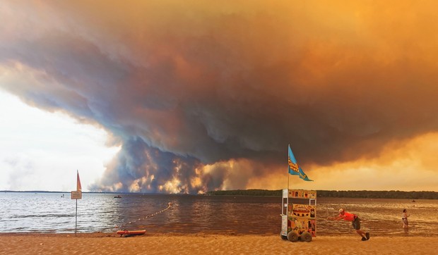 Posetioci plaže odmaraju se na plaži Mučik na obali jezera Lakano u Lakanou, na jugozapadu Francuske, dok požar besni u Žirondi, 24. jul 2026.