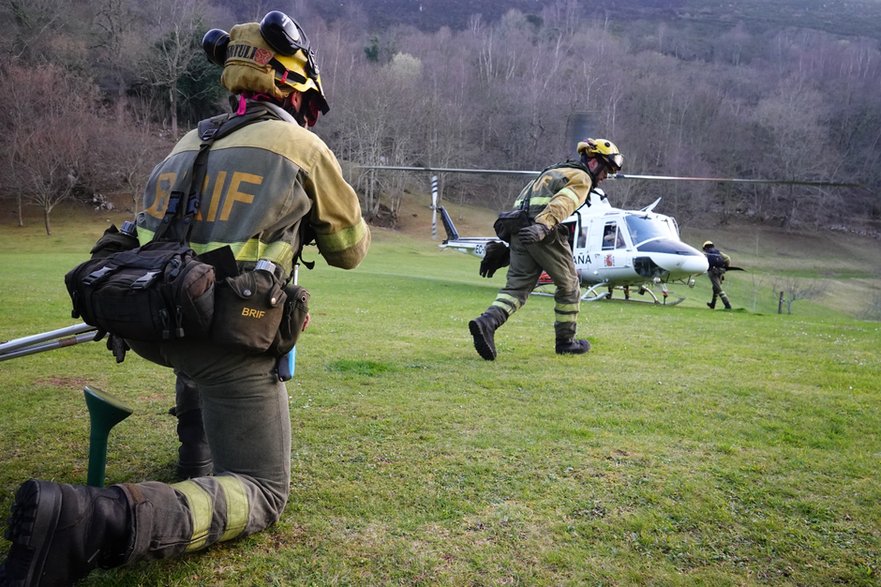 Bomberos antes de despegar en un helicóptero para combatir un incendio forestal en la región española de Asturias el 10 de marzo de 2023.