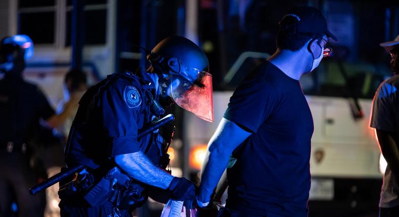 police arrest george floyd protest houston Police officers begin the intake process after a group of protesters were caught and arrested after escaping a caged in area on June 2, 2020 in Houston, Texas. No rioting or looting was reported but a group of protesters tried running from police after unconfirmed reports that they were trying to get on the freeway. (Photo by Sergio Flores/Getty Images)