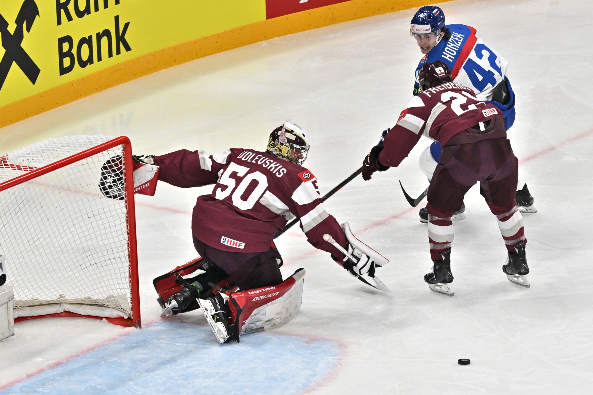 Zľava lotyšský brankár Kristers Gudlevskis, Ralfs Freibergs (Lotyšsko) a Samuel Honzek (Slovensko). 