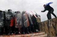 Protesters clash with police officers during a demonstration against the agreement reached by Greece