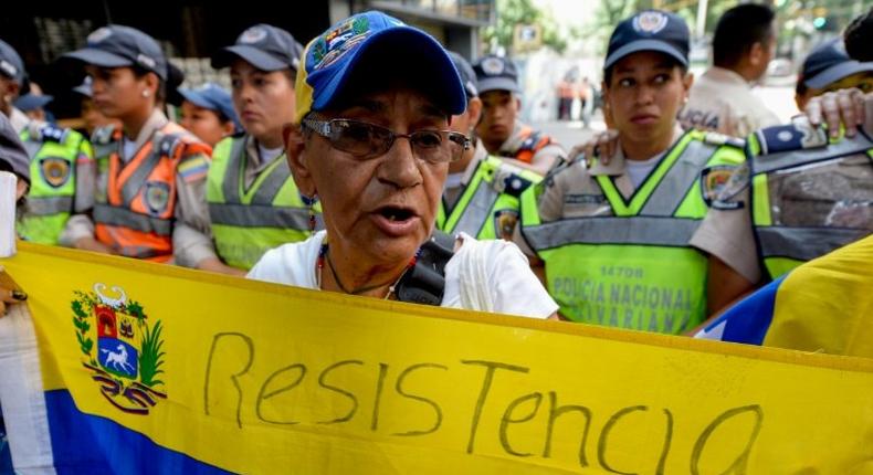 An opposition supporter holds a Venezuela's national flag as she marches protesting against the government of President Nicolas Maduro, in Caracas, on November 10, 2016