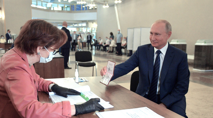Vlagyimir Putyin orosz elnök megmutatja útlevelét egy szavazóhelyiségben / Fotó: MTI/EPA/Szputnyik/Kreml/Pool/Alekszej Druzsinyin