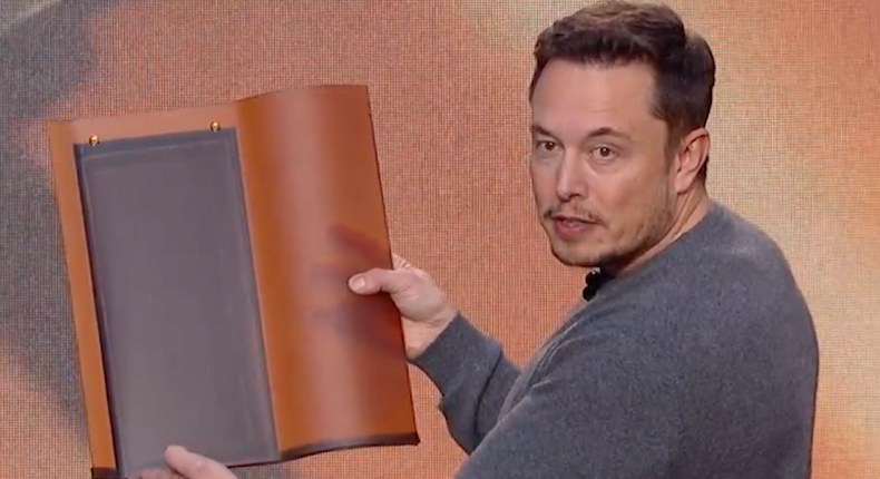 Tesla CEO Elon Musk holds the company's tuscan solar roof tile.