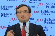 Zbigniew Ziobro w tle logo Solidarna Polska