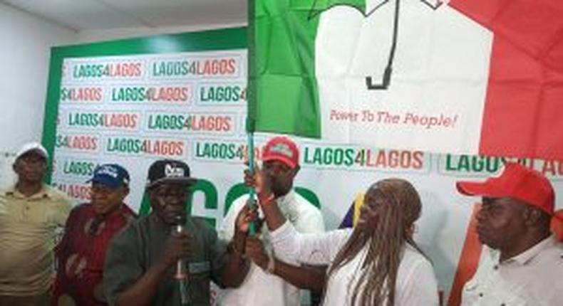 PDP Chairman, Mr Philips Aivoji, handling over the party’s flag to the leader of the defectors, Miss Dabiraoluwa Adeyinka on Monday in Lagos.