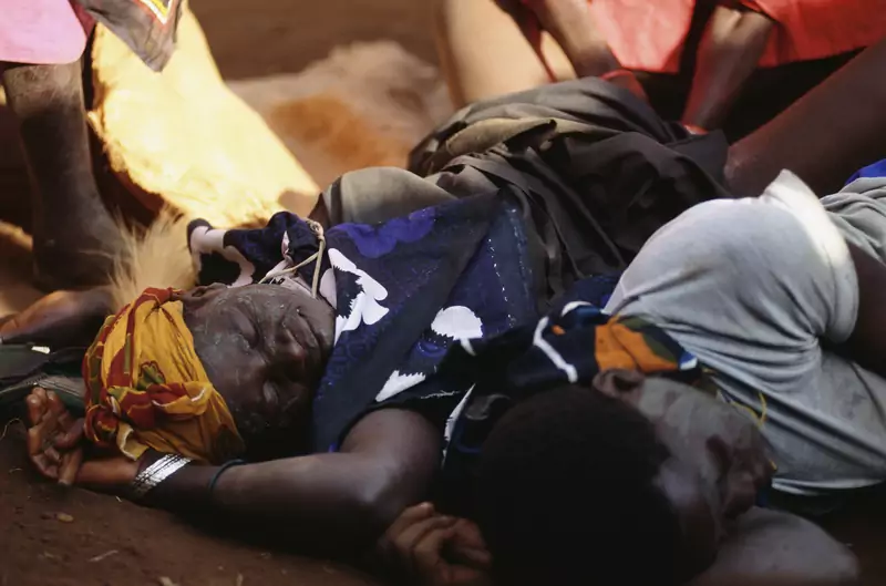 Kobieta leżąca na ziemi po odbyciu &quot;rytuału przejścia&quot; w postaci obrzezania, Uganda / Getty Images