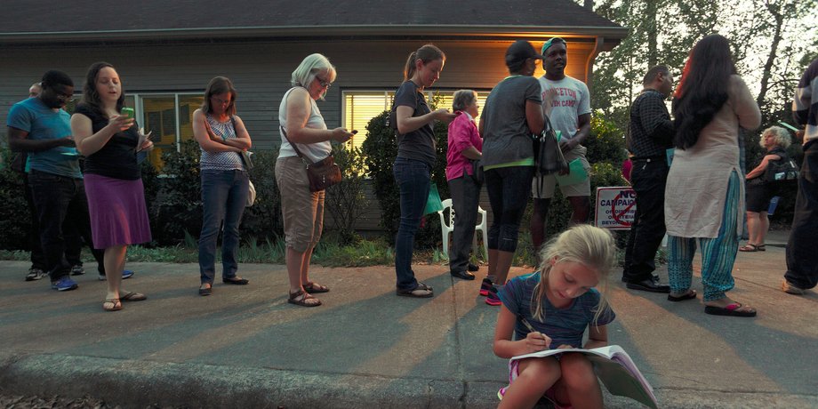 Louisa Weinard, 9, works on her homework while her mother waits in a line at a polling station open into the evening as early voting for the 2016 general elections begins in Durham, North Carolina, U.S., October 20, 2016.