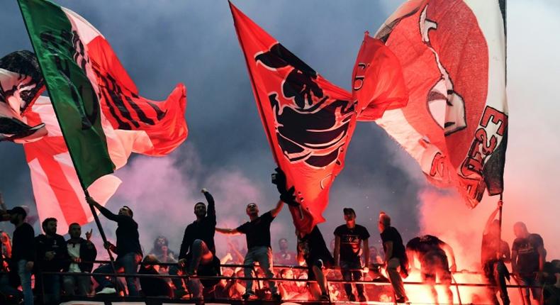 AC Milan fans wave flags during the city derby against Inter Milan in the San Siro stadium.