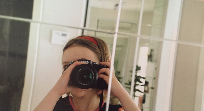 Finley Muratova, pictured here at age 10 taking a selfie with their father's camera.
