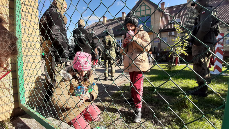 Dzieci migrantów przy ogrodzeniu placówki Straży Granicznej w Michałowie.