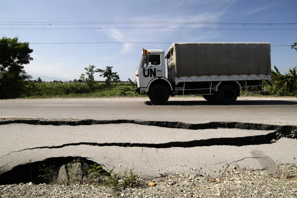 A truck with U.N. soldiers from Sri Lanka transports electoral material past a road damaged during January's earthquake near Leogane