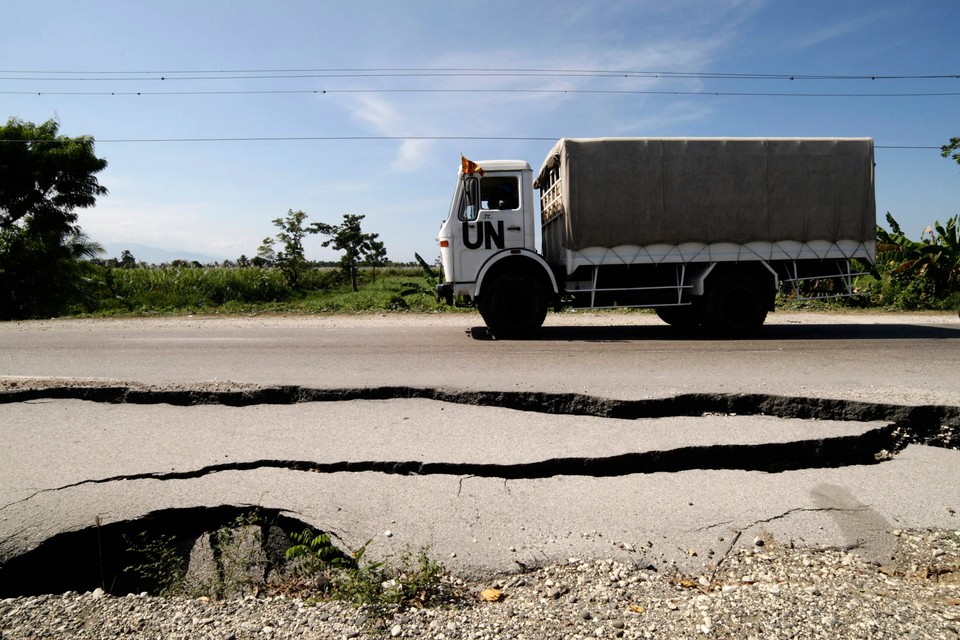 A truck with U.N. soldiers from Sri Lanka transports electoral material past a road damaged during January's earthquake near Leogane