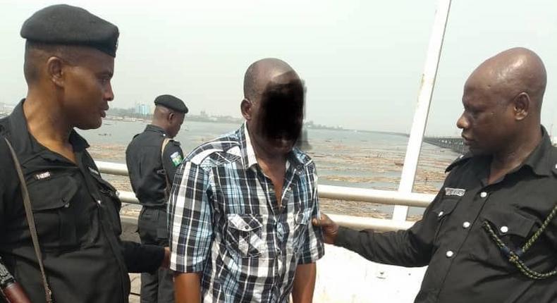 Police officers take a man into custody after a failed suicide attempt on the Third Mainland Bridge, Lagos in January 2019 [RRS]