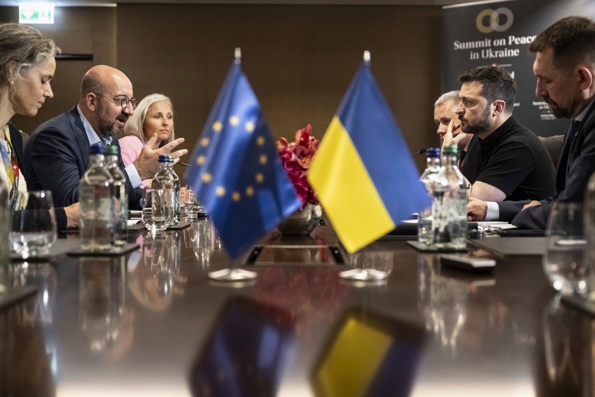 Ukrajinský prezident Volodymyr Zelenskyj (druhý sprava) a predseda Európskej rady Charles Michel (druhý zľava) sa rozprávajú počas ich bilaterálneho stretnutia na mierovom summite o Ukrajine.