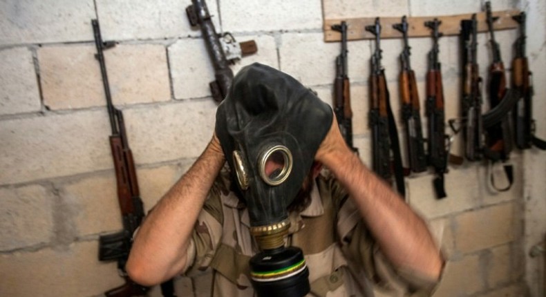 A rebel tries on a gas mask seized from a Syrian army factory in the north-western province of Idlib