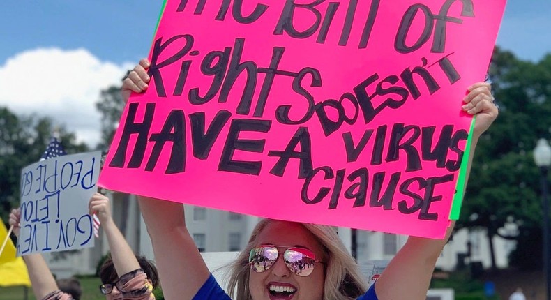 Kimmy Tillery, a hair dresser from Tuscaloosa, Ala., holds a sign during a protest to reopen Alabama's economy outside the Capitol in Montgomery, Ala., on Tuesday, April 21, 2020.