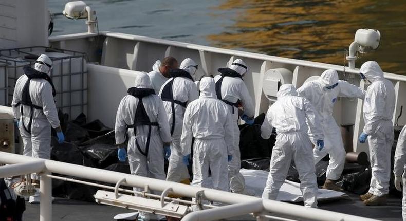 Italian coastguard and Armed Forces of Malta personnel in protective clothing stand near the bodies of dead immigrants on the ship Bruno Gregoretti in Senglea in Valletta's Grand Harbour, April 20, 2015. REUTERS/Darrin Zammit Lupi