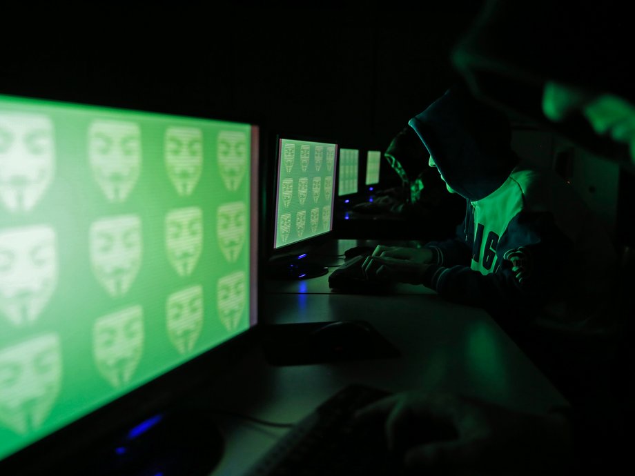 People pose in front of a display showing the word 'cyber' in binary code, in this picture illustration taken in Zenica December 27, 2014.