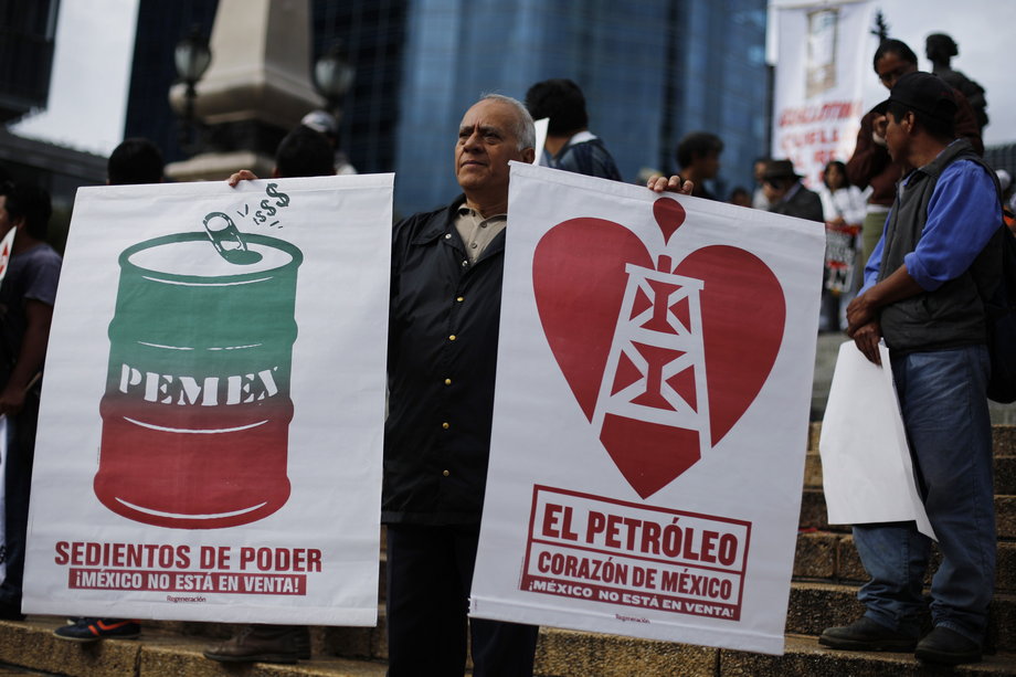 A supporter of Mexican leftist Andres Manuel Lopez Obrador protests against energy reforms in Mexico City on September 22, 2013. The posters read "Thirsting for power. Mexico is not for sale," on the left, and "Oil, heart of Mexico."