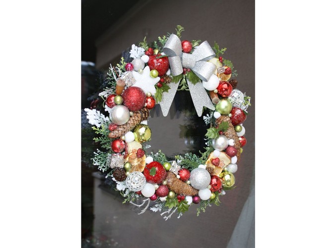 Bożonarodzeniowy wianek ze srebrnymi, zielonymi i czerwonymi dekoracjami, ozdobiony kokardą. Autorka: Marta Jarosińska-Mańka