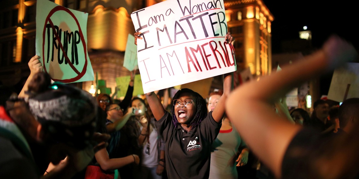 A female protester holds a sign during an anti-Trump march in downtown San Diego, California.