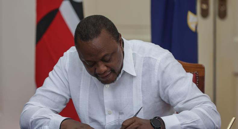 President Uhuru Kenyatta  signing documents at State House, Nairobi