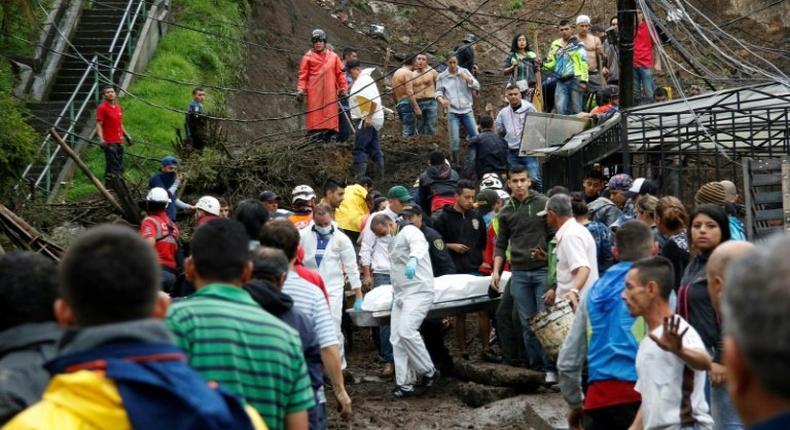 Rescuers carry a corpse following deadly mudslides in the central Colombian city of Manizales