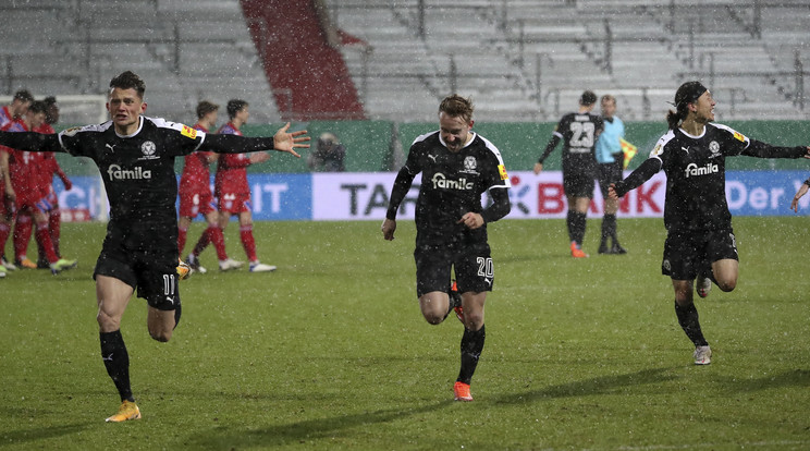 Boldog kieli játékosok, a háttérben szomú Bayern-futballisták. / Fotó: EPA/Fokke Strangmann.