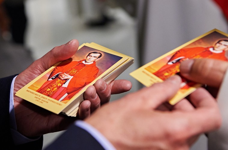 Francuz Francois Audelan rozdaje wiernym obrazki z wizerunkiem ks. Jerzego Popiełuszki, po mszy świętej w kościele katedralnym w Creteil