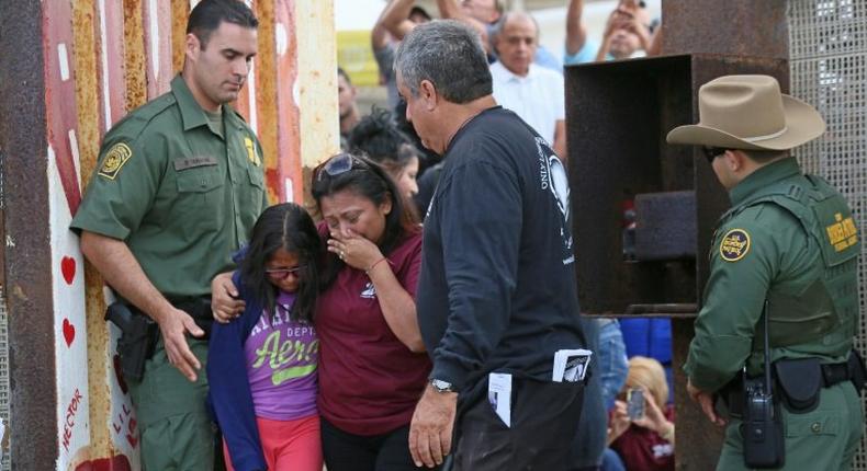 Laura Avila hugs her own daughter after getting to see her mother for three minutes at a specially organized event on the US-Mexico border