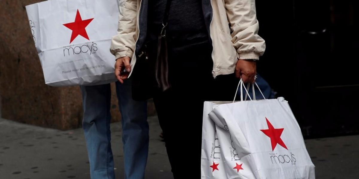 People hold Macy's shopping bags outside the store at the Herald Square location in New York