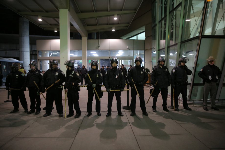 Port Authority Police Department officers blocking protesters gathered outside Terminal 4 at JFK airport on Saturday.