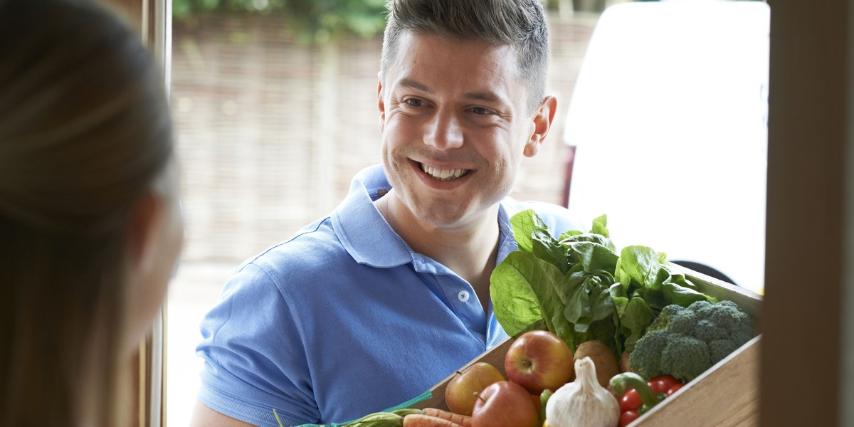 Groceries and packages delivery, covid-19, quarantine and shopping concept. Smiling delivery man in 