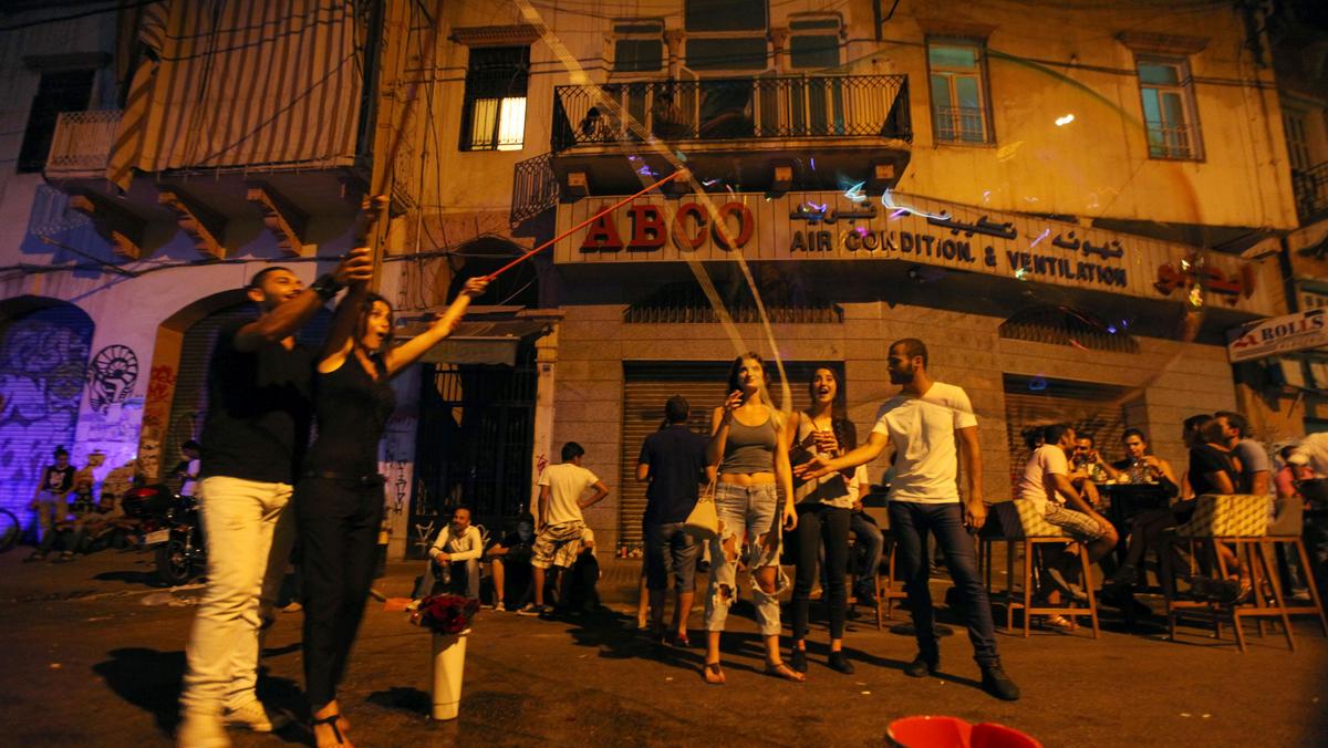People react to a giant soap bubble during a music festival in Mar Mikhael area in Beirut
