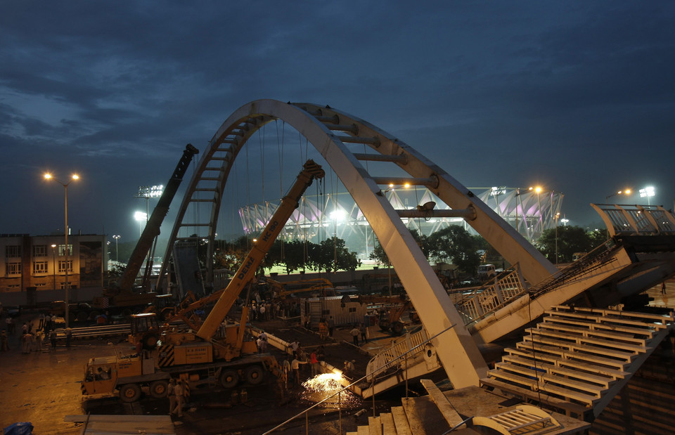 Cranes work at the site of a pedestrian bridge that collapsed outside the Jawaharlal Nehru Stadium in New Delhi