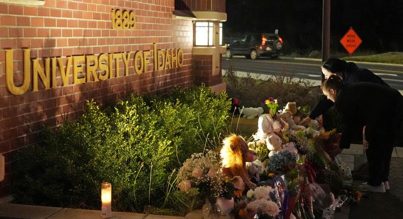 Two people place flowers at a growing memorial in front of a campus entrance sign for the University of Idaho, Wednesday, Nov. 16, 2022, in Moscow, Idaho.AP Photo/Ted S. Warren