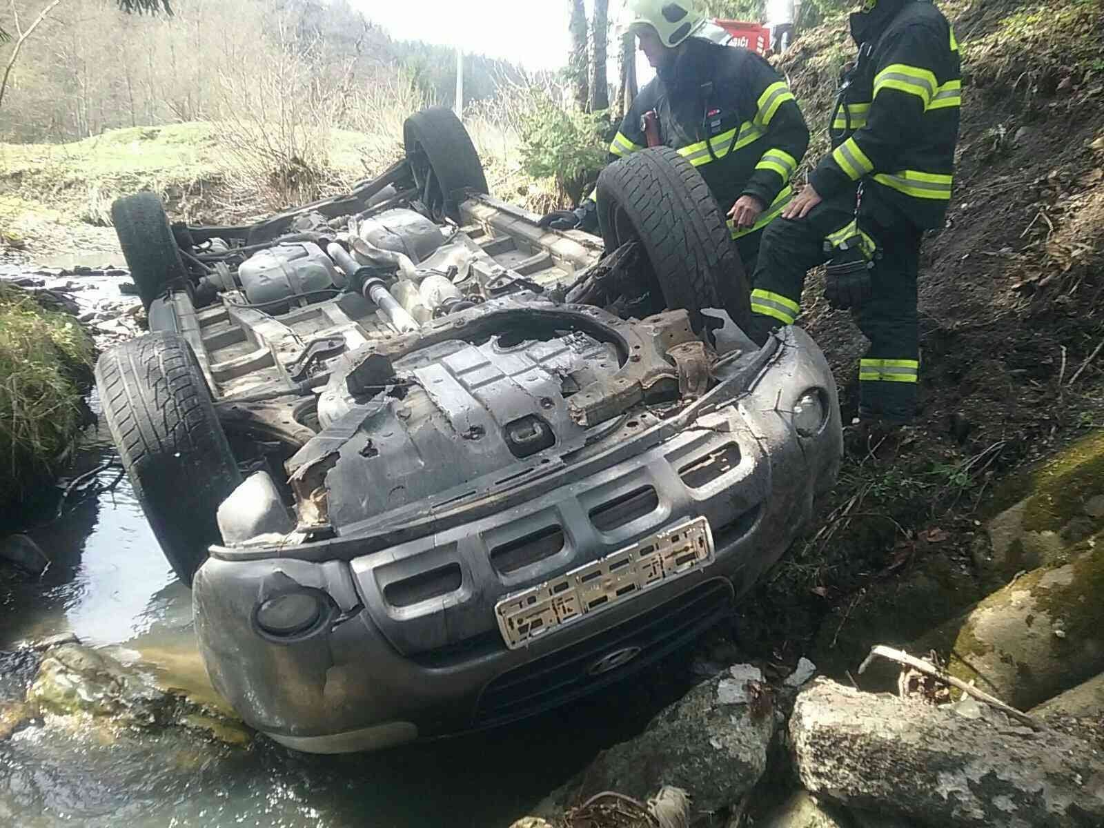 Druhé auto skončilo na streche v potoku. 