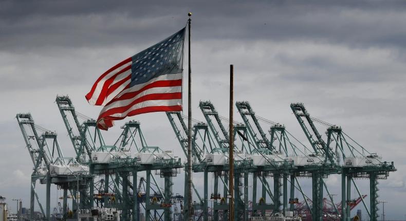 The US flag flies over shipping cranes and containers in Long Beach, California, where a lot of Chinese exports land